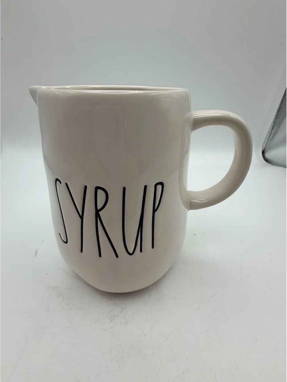 Rae Dunn white ceramic syrup pitcher.with handle. In like new condition